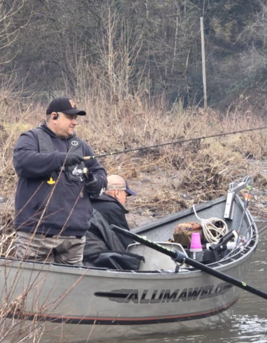 Two anglers fishing from an Alumaweld drift boat along a brushy bank