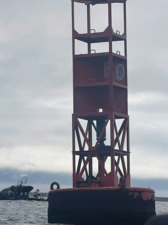 Red channel marker buoy on the water
