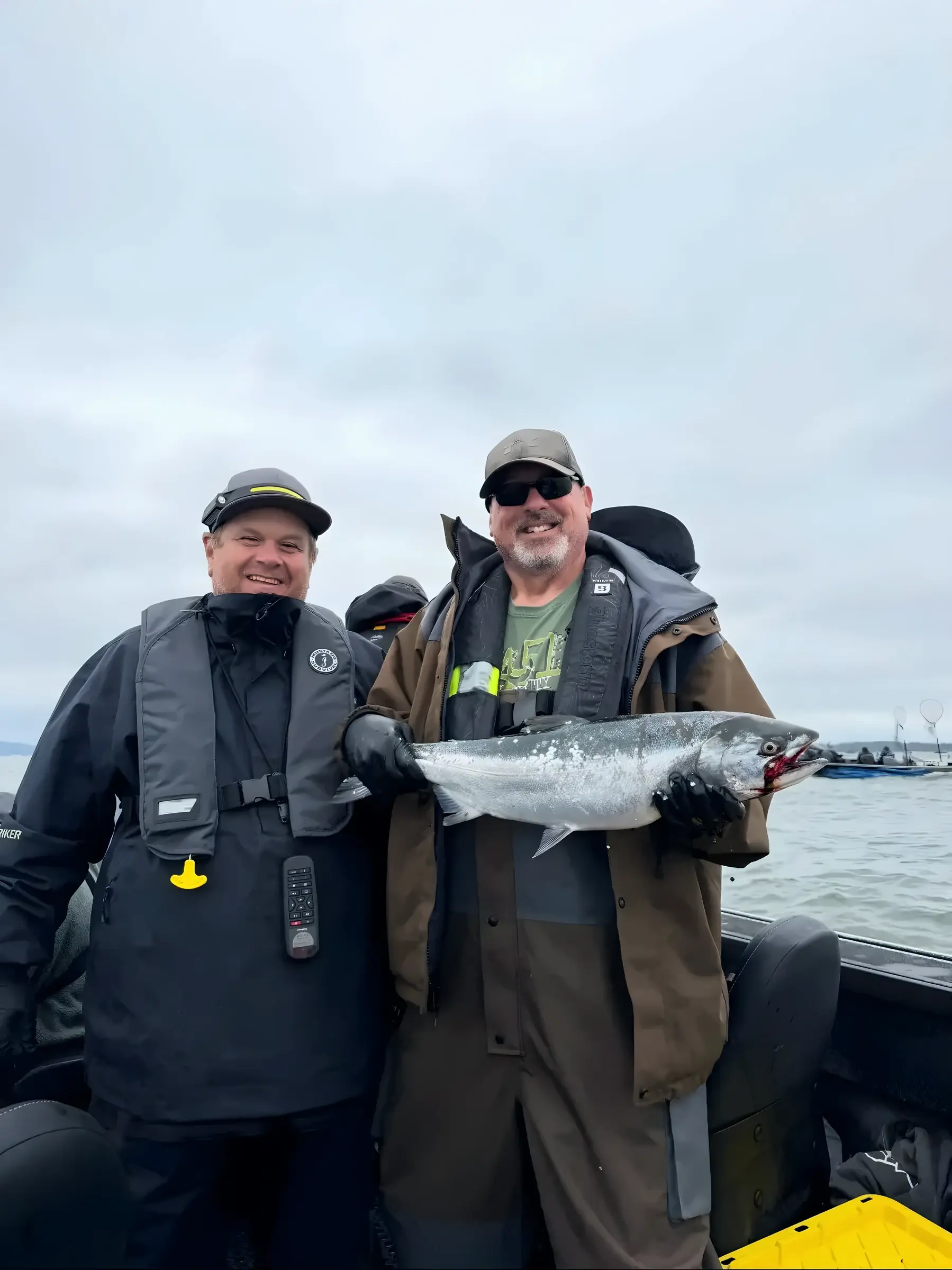 Two anglers on a boat holding a fish