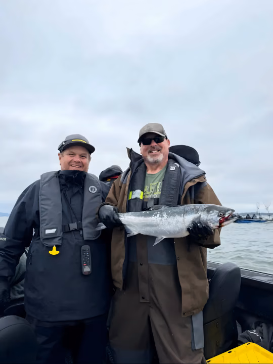 Two anglers posing with a fish after a trip