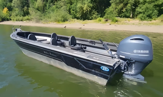 Aluminium fishing boat with a Yamaha outboard anchored in shallow green water